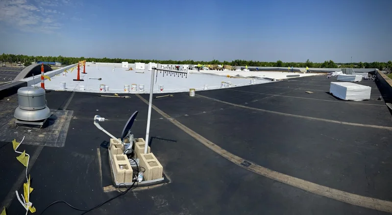Membrane installation in progress across a large commercial flat roof