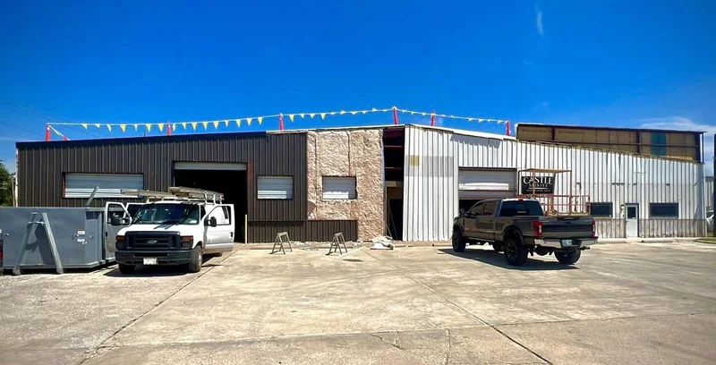 Commercial metal building with crews and equipment outside