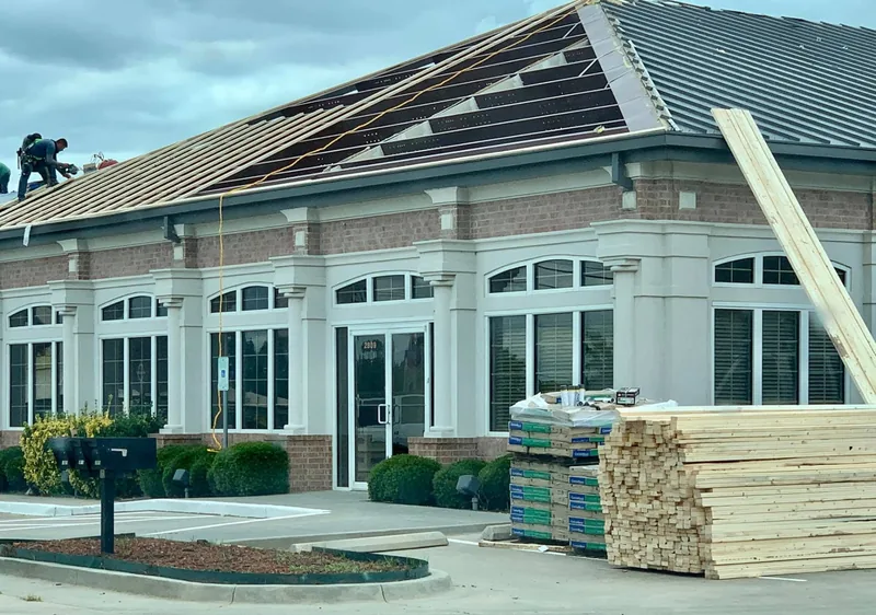 Standing-seam metal roof installation on a commercial office building