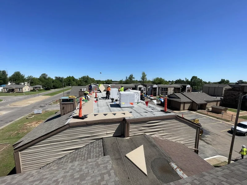 Roofing crew installing materials on a low-slope commercial roof