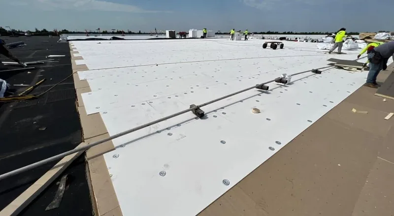 White TPO membrane installation on a large flat roof