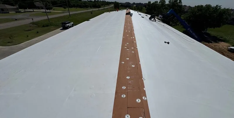 TPO roofing membrane and fastened seam strip on a commercial roof