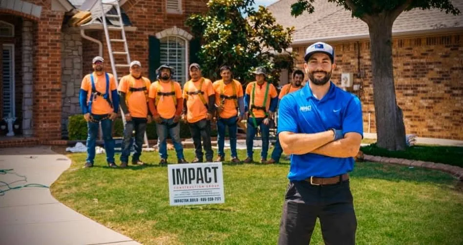 Impact Construction Group roofing crew in safety harnesses with an Impact yard sign