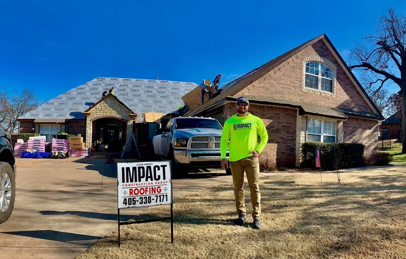 Roof replacement in progress behind an Impact Roofing yard sign
